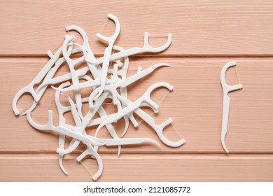 Many floss toothpicks on pink wooden background