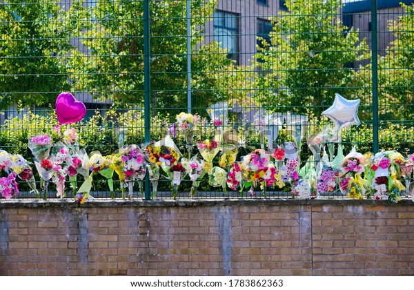 Many flowers in memorial at school for road accident\
death 