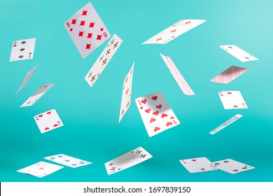many flying playing cards on a turquoise background - Shutterstock ID 1697839150