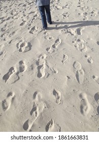 Many Footprints Left Behind In The Sun Soaked White Sand Of The Beach