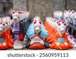 Many fox figurines and statues at Fushimi Inari Shrine, Kyoto Japan. ( English translation of the text from japanese : The rice entrance).