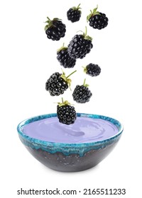 Many Fresh Blackberries Falling Into Bowl Of Yogurt On White Background