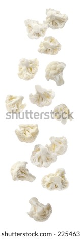 Many fresh cauliflower florets falling on white background
