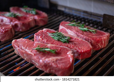 Many Fresh New York Strip Cut Beef - Barbeque Meat on a Grill, decorated with Rosemary