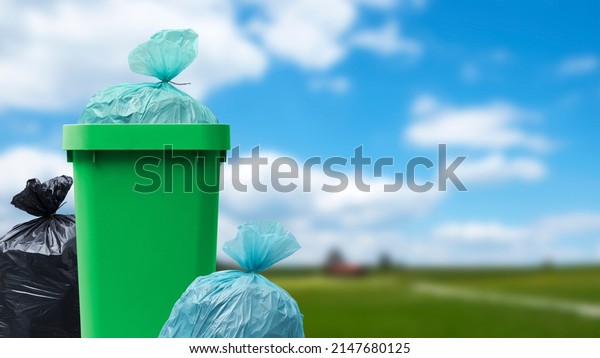 Many garbage bags and full waste bin at the park,\
waste management concept