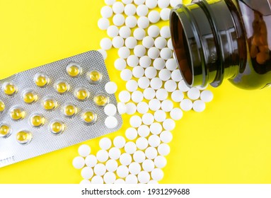 Many Gel Capsules Of Vitamin D3 2000 IU And Vitamin K2 Pills On Yellow Background
