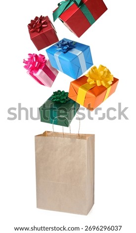 Many gift boxes falling into paper bag on white background