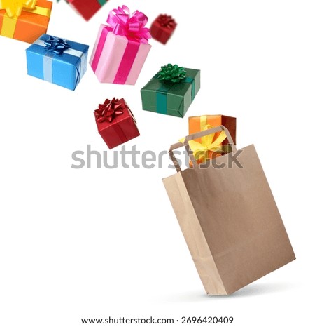 Many gift boxes falling into paper bag on white background
