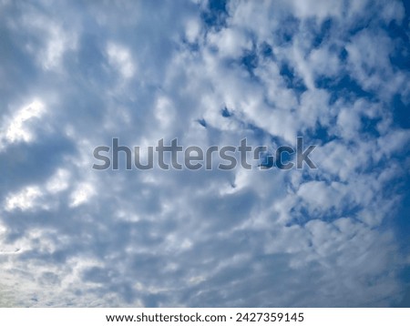 Many glowing clouds spreading on the deep blue sky in daylight. Multitude soft white fluffy clouds covered the entire blue sky. Nature concept. Elegant white clouds in sunny day. Landscape photo