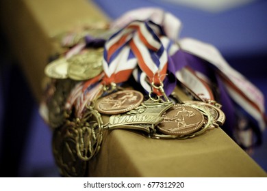 Many Gymnastic Medals, Ribbons On Top Of Balance Beam