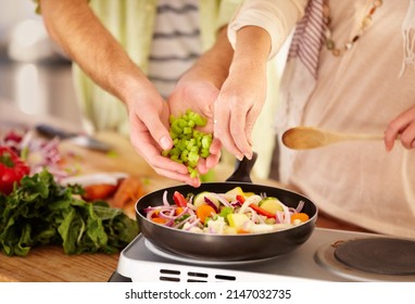 Many Hands Make Light Work. Cropped Image Of A Married Couple Cooking In The Kitchen.