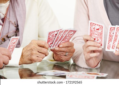 Many Hands Of Senior Adults Playing Cards Together