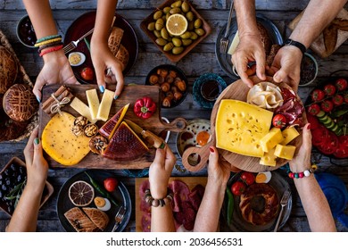 Many Hands Sharing Cheese And Bacon And Ham From Two Different Serving Boards. 