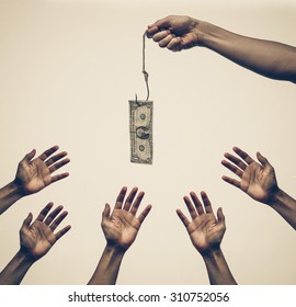 Many Hands Trying To Get A Dollar Banknote Hung On A Fish Hook