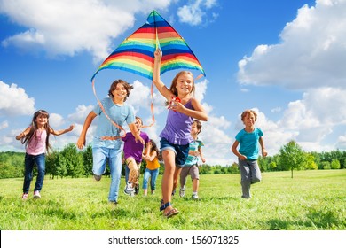 Many Happy Active Kids Boys And Girls Run With Kite In The Park