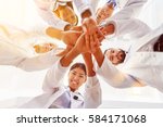 Many happy doctors stack hands together as team for motivation