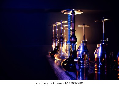 many hookahs with shisha glass flasks and metal bowls in the hookah room