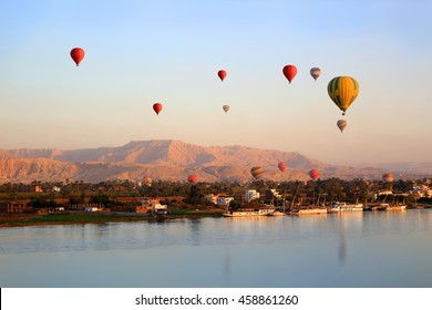 Viele Heißluftballons schwimmen bei Sonnenaufgang über dem Nil in Luxor