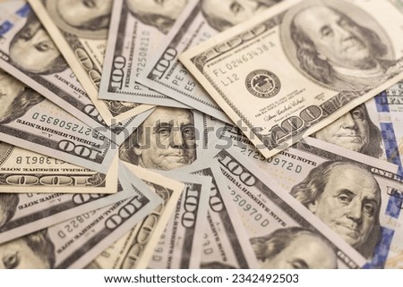 Many hundred dollar bills on wooden table background texture. bundles of money scattered on the office desk. wealth and income concept
