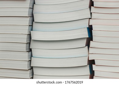 Many Identical Books Are Stacked On Top Of Each Other In A Glass Display Case Of A Bookstore.