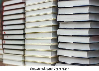 Many Identical Books Are Stacked On Top Of Each Other In A Glass Display Case Of A Bookstore.