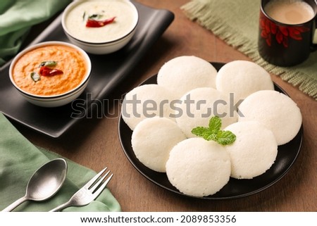 Many Idli or idly popular breakfast of Kerala South India and Sri Lanka. Healthy steamed rice cakes by steaming fermented batter of black lentils and rice coconut chutney tomato chutney.