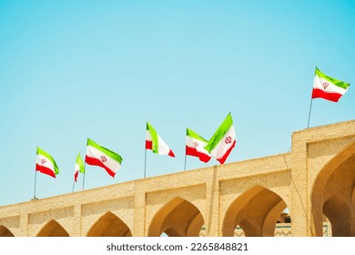 Many iranian flags wave in wind on rooftop of building