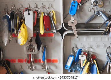 many keys with multi-colored key chains hang in the key keeper