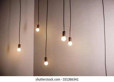 Many Lamps On A Long Cord And Hanging Light In The Room.