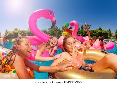 Viele lachende Mädchen schwimmen und schwimmen im Sommer in einer Gruppe von Freunden im Pool im Freien auf aufblasbarem Spielzeug