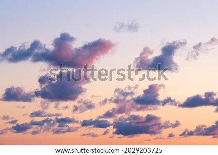 Many little clouds on orange - blue sky background. Dramatic sky during sunset. Latvia nature