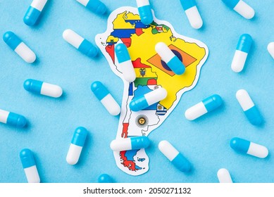 Many medical pills, capsules on top of map and flag of South America Continent. Epidemic on the continent, dangerous disease