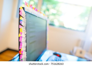 Many memo post-it stuck to the edge of the work computer in office