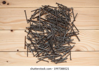 Many metal nails on wooden background, flat lay. A collection of rusty, dusty and dirty iron nails wooden background. Space for text.