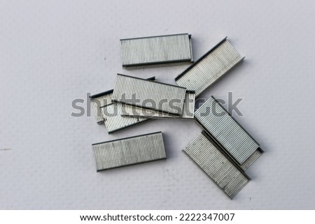 Many of Metal staples for stapler on white background. Selective focuss blurry background 