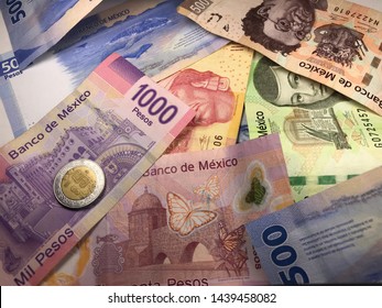 Many Mexican Pesos And Other Latin American Money Bills Spread Over A Wooden Desk Inside A Small Business Office