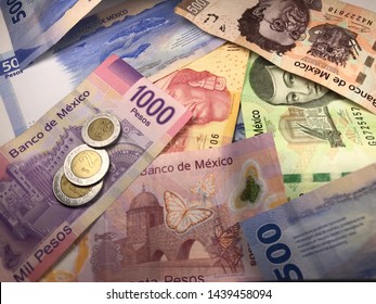 Many Mexican Pesos And Other Latin American Money Bills Spread Over A Wooden Desk Inside A Small Business Office