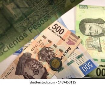 Many Mexican Pesos And Other Latin American Money Bills Spread Over A Wooden Desk Inside A Small Business Office