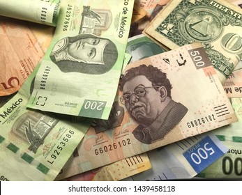 Many Mexican Pesos And Other Latin American Money Bills Spread Over A Wooden Desk Inside A Small Business Office