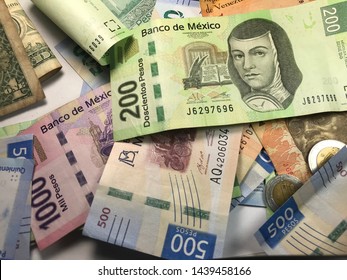 Many Mexican Pesos And Other Latin American Money Bills Spread Over A Wooden Desk Inside A Small Business Office