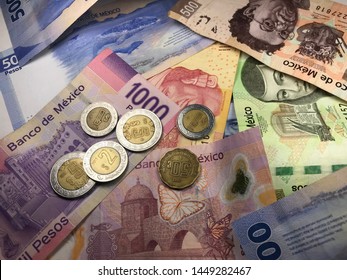 Many Mexican Pesos And Other Latin American Money Bills Spread Over A Wooden Desk Inside A Small Business Office