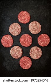 Many Minced Steak Burgers  In Geometric  Pattern  Isolated On Black Background, Overhead View. Raw Ground Beef, Round Patties For Cooking Homemade Burger On BBQ Grill, Top View