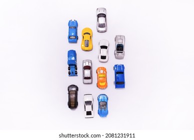 Many Miniature Toy Cars On White Background. The Group Of Car Toy On The Road.Top View,copy Space. Traffic Jam Concept With Multiple Toy Cars.