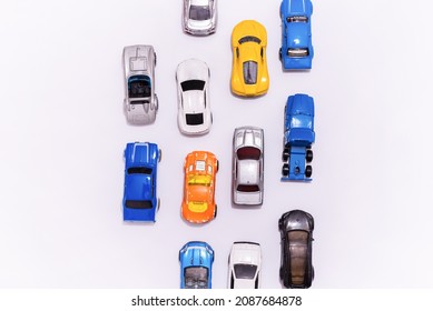 Many Miniature Toy Cars On White Background. The Group Of Car Toy On The Road.Top View,copy Space. Traffic Jam Concept With Multiple Toy Cars.