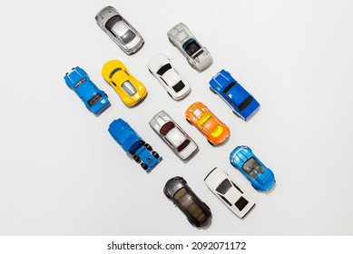 Many Miniature Toy Cars On White Background. The Group Of Car Toy On The Road.Top View,copy Space. Traffic Jam Concept With Multiple Toy Cars.