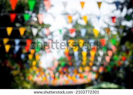 Many multicolored triangular flags adorn the blurred garden. , postcard background, Valentine's Day