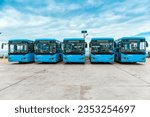 Many new energy electric buses are neatly parked in the outdoor parking lot
