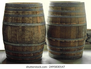 Many old aged wooden barrels with iron rusty  hoops in cellar, banner design. Wine or cognac barrels in winery, beer barrels. wine vaults. vintage oak barrels of craft brandy. standing on the floor