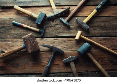 Many old hammers on wooden table