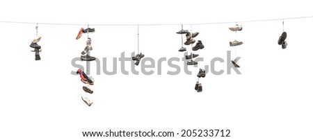 Many old worn boots or shoes hang on an electric cable